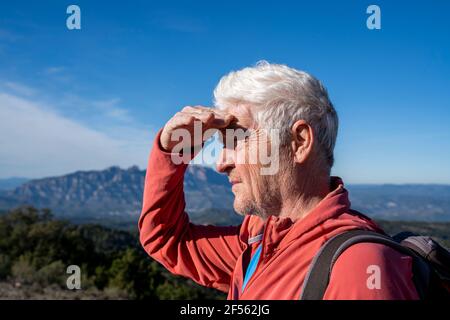 Uomo anziano che ammira la vista mentre si alza contro il cielo a Sant Llorenc del Munt i l'Obac, Catalogna, Spagna Foto Stock