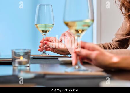 Giovani donne che tengono bicchieri di vino al ristorante Foto Stock