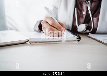 Donna professionista medico scrittura in diario Foto Stock