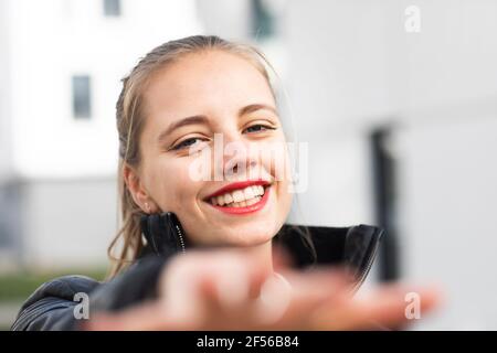 Ritratto di giovane biondo bello che raggiunge verso la macchina fotografica Foto Stock