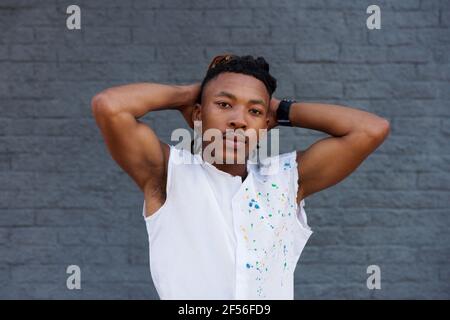 Ritratto di uomo africano sicuro in piedi con le mani dietro la testa Foto Stock