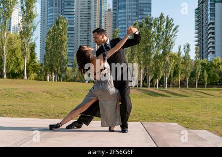 Ballerini maschili e femminili che ballano nel parco pubblico Foto Stock