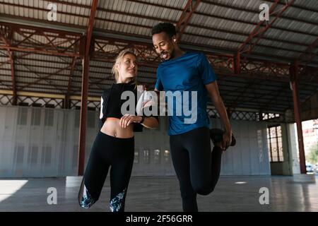 Atleti di sesso maschile e femminile che fanno esercizio di riscaldamento in salute club Foto Stock