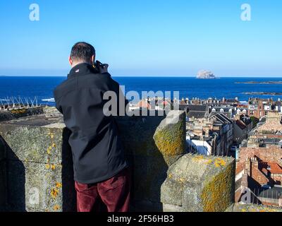 Uomo che scatta fotografie dalla cima della torre della chiesa di St Andrew Blackadder, a nord di Berwick Foto Stock