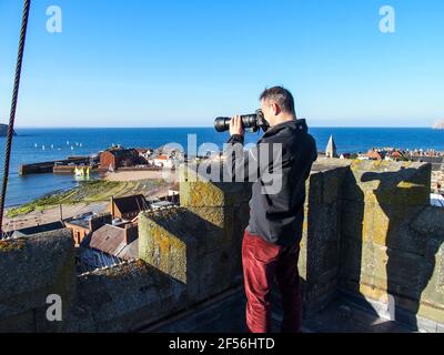 Uomo che scatta fotografie dalla cima della torre della chiesa di St Andrew Blackadder, a nord di Berwick Foto Stock