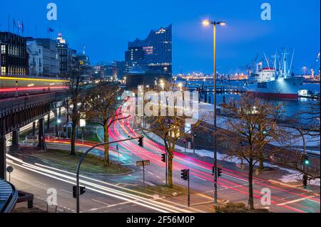 Germania, Amburgo, sentieri per veicoli leggeri che si estendono lungo la strada del porto all'alba con Elbphilmarmonie sullo sfondo Foto Stock