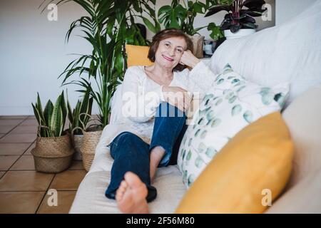Senior donna rilassante sul divano di casa Foto Stock