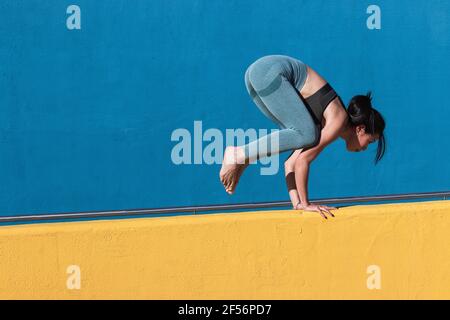 Donna che fa la maniglia sul muro di ritegno Foto Stock