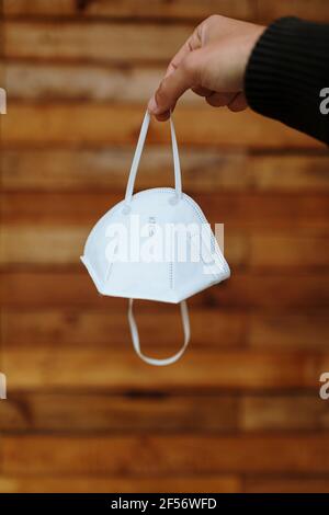 Uomo che tiene la maschera protettiva contro la parete Foto Stock