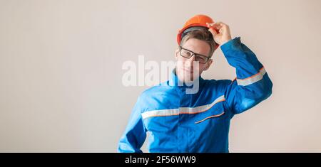 un giovane lavoratore maschio che tiene un casco, attrezzature di sicurezza industriale Foto Stock