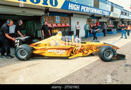 2001 Donington Park Racing Circuit ,Castle Donington ,Leicestershire ,East Midlands, Inghilterra, GB, UK, Europa - Paul Stoddart guida Neale Clark in una Formula europea Racing due posti Minardi F1 auto fuori dai box al circuito di Donington Park. Questo eccezionale giro in auto da corsa a due posti offre un'emozione a velocità di strappo per un'esperienza indimenticabile nella lista dei secchielli. Paul Stoddart, a partire dal Gran Premio di Spagna 2017, offre agli appassionati la possibilità di guidare in una delle sue vetture Minardi FX2 Foto Stock