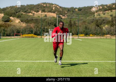 Corridore di velocità sportivo nero, che corre in un campo di calcio. Foto Stock