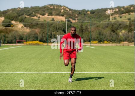 Formazione professionale di corridori neri afro in un campo. Foto Stock