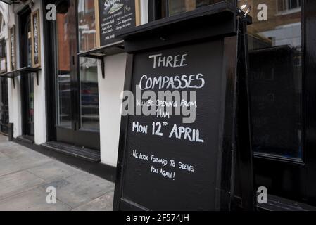 Londra, Regno Unito. 24 marzo 2021. Un cartello all'esterno del pub Three Compasses di Farringdon informa il pubblico che intende riaprire il 12 aprile. Attualmente chiuso a causa della pandemia di coronavirus in corso, il pub accoglierà i bevitori una volta attenuate le restrizioni secondo la tabella di marcia del governo britannico. Credit: Stephen Chung / Alamy Live News Foto Stock