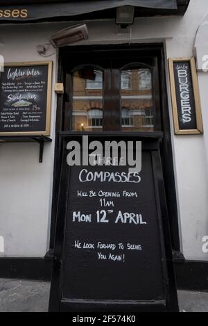 Londra, Regno Unito. 24 marzo 2021. Un cartello all'esterno del pub Three Compasses di Farringdon informa il pubblico che intende riaprire il 12 aprile. Attualmente chiuso a causa della pandemia di coronavirus in corso, il pub accoglierà i bevitori una volta attenuate le restrizioni secondo la tabella di marcia del governo britannico. Credit: Stephen Chung / Alamy Live News Foto Stock