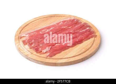 Strisce di pancetta su tagliere di legno isolate su bianco Foto Stock