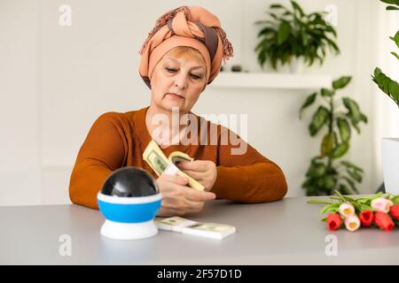 Donna psichica o cassiere di fortuna gesturing con le mani che indicano denaro Foto Stock
