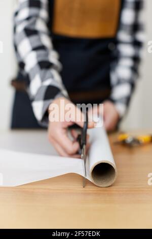 fiorista donna taglio carta su tavola con piante. Foto Stock