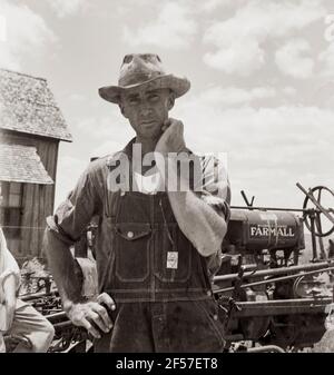 L'ex agricoltore in un'ampia fattoria di cotone ora è un macchinista per un dollaro al giorno nella stessa azienda. Bell County, Texas. Giugno 1937. Fotografia di Dorothea Lange. Foto Stock