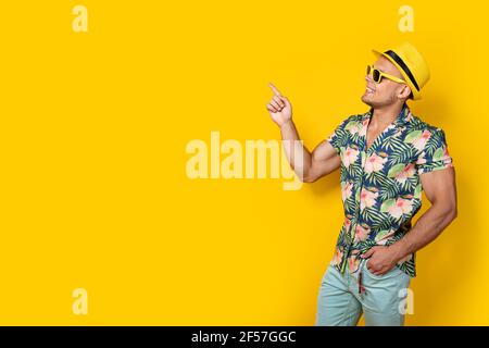 Uomo in abiti luminosi con bevanda sul giallo Foto Stock