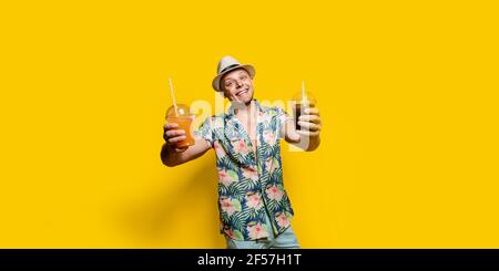Uomo in abiti luminosi con bevanda sul giallo Foto Stock