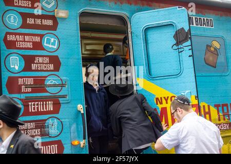New York, Stati Uniti. 24 Marzo 2021. I membri della comunità di Lubavitcher prendono una pausa dalla loro Parata di passaggio dei carri armati Mitzvah a Chelsea a New York mercoledì 24 marzo 2021. La setta di Lubavitcher degli Hasidim, i adoratori ebrei ultra-ortodossi, continua a fare il loro sproach ai membri decaduti della fede ebraica. La Pasqua inizia la sera di sabato 27 marzo. (ÂPhoto di Richard B. Levine) Credit: Sipa USA/Alamy Live News Foto Stock