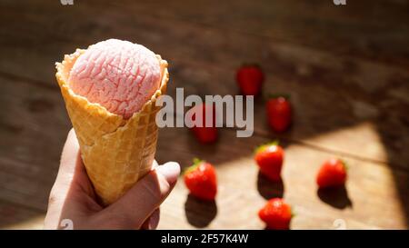 Primo piano immagine della mano donna che tiene il gelato al lampone Foto Stock