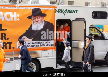 I membri della comunità di Lubavitcher prendono una pausa dalla loro Parata di passaggio dei carri armati Mitzvah a Chelsea a New York mercoledì 24 marzo 2021. La setta di Lubavitcher degli Hasidim, i adoratori ebrei ultra-ortodossi, continua a fare il loro sproach ai membri decaduti della fede ebraica. La Pasqua inizia la sera di sabato 27 marzo. (© Richard B. Levine) Foto Stock