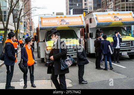I membri della comunità di Lubavitcher prendono una pausa dalla loro Parata di passaggio dei carri armati Mitzvah a Chelsea a New York mercoledì 24 marzo 2021. La setta di Lubavitcher degli Hasidim, i adoratori ebrei ultra-ortodossi, continua a fare il loro sproach ai membri decaduti della fede ebraica. La Pasqua inizia la sera di sabato 27 marzo. (© Richard B. Levine) Foto Stock