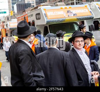 I membri della comunità di Lubavitcher prendono una pausa dalla loro Parata di passaggio dei carri armati Mitzvah a Chelsea a New York mercoledì 24 marzo 2021. La setta di Lubavitcher degli Hasidim, i adoratori ebrei ultra-ortodossi, continua a fare il loro sproach ai membri decaduti della fede ebraica. La Pasqua inizia la sera di sabato 27 marzo. (© Richard B. Levine) Foto Stock