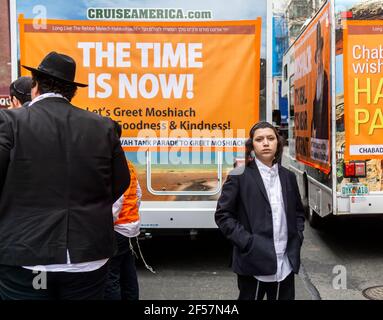I membri della comunità di Lubavitcher prendono una pausa dalla loro Parata di passaggio dei carri armati Mitzvah a Chelsea a New York mercoledì 24 marzo 2021. La setta di Lubavitcher degli Hasidim, i adoratori ebrei ultra-ortodossi, continua a fare il loro sproach ai membri decaduti della fede ebraica. La Pasqua inizia la sera di sabato 27 marzo. (© Richard B. Levine) Foto Stock