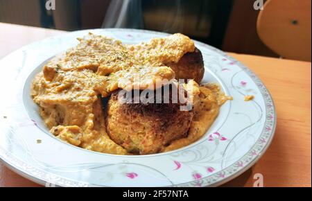 Fuoco selettivo di una cucina indiana calda e affumicata deliziosa Curry Malai Kofta al forno - un piatto di specialità Mughlai fatto di noci di anacardi servite su un piatto Foto Stock