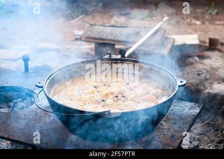 Calderone con riso bollito, incontro, carote e altri ingredienti, vista ravvicinata pilaff cottura. Riso pilaf cottura serie Foto Stock
