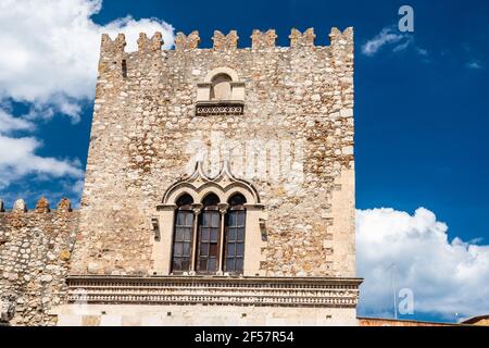 Vista ad angolo basso di un edificio storico a Taormina contro un cielo blu con nuvole, Italia Foto Stock