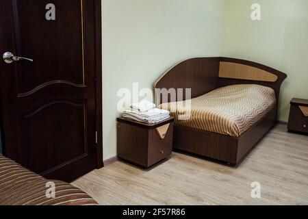 una camera in un hotel economico. interni minimalistici di una camera d'albergo di classe economica. pernottamento per il viaggiatore. diversi letti e un tavolo Foto Stock