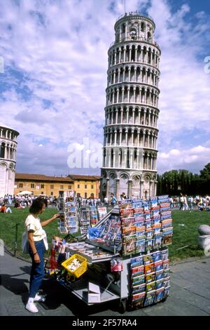 Donna che guarda i souvenir di fronte alla Torre Pendente Di Pisa in Italia Foto Stock