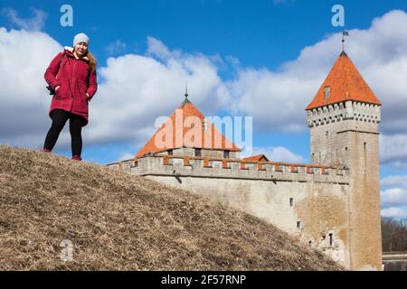 Giovane donna in piedi sulle torri agaiste di collina del castello episcopale di Kuressaare. La ciy di Kuressaare, l'isola di Saaremaa, Estonia Foto Stock