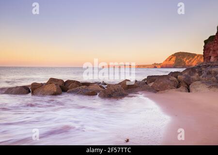 Un'alba di prima estate sul mare a Sidmouth, Devon Foto Stock