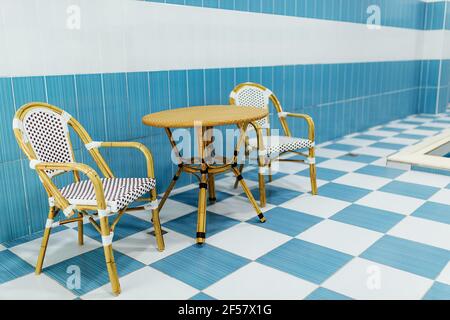 sedie in legno sul pavimento piastrellato.area salotto per gli ospiti vicino alla piscina nel complesso termale Foto Stock