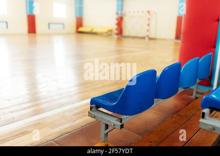 colorato significa tifosi in uno stadio al coperto. posti a sedere nella sala sportiva per le competizioni. panca vuota dei giocatori di riserva Foto Stock