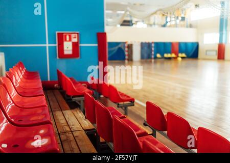 colorato significa tifosi in uno stadio al coperto. posti a sedere nella sala sportiva per le competizioni. panca vuota dei giocatori di riserva Foto Stock