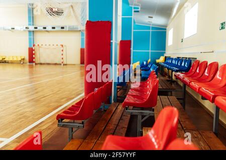 colorato significa tifosi in uno stadio al coperto. posti a sedere nella sala sportiva per le competizioni. panca vuota dei giocatori di riserva Foto Stock