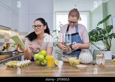 Mamma e figlia presea che cucinano insieme a casa Foto Stock