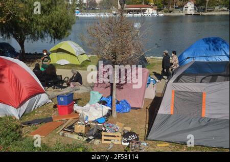 Los Angeles, Stati Uniti. 24 Marzo 2021. I residenti locali camminano oltre un accampamento senza dimora al lago Echo Park a Los Angeles lunedì 23 marzo 2021. Il Los Angeles.Times ha riferito che l'accampamento di persone non ospitate presso il parco sarà autorizzato entro giovedì e le recinzioni saranno installate per mantenere il parco chiuso per lavori di ristrutturazione, per ciò che viene descritto come più di 500,000 dollari in lavori di riparazione, comprese le riparazioni di illuminazione e tubazioni danneggiate, rimozione di materiali pericolosi e miglioramenti della sicurezza pubblica. Foto di Jim Ruymen/UPI Credit: UPI/Alamy Live News Foto Stock