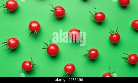 pomodori ciliegini freschi su sfondo verde, vista dall'alto Foto Stock