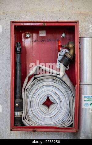 Primo piano dell'idrante antincendio e del tubo flessibile Foto Stock