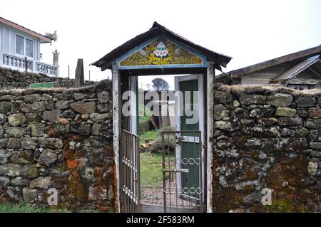 Una bella porta decorata altamente e colorata di un Budhist monastero con muro di pietra boundry Foto Stock