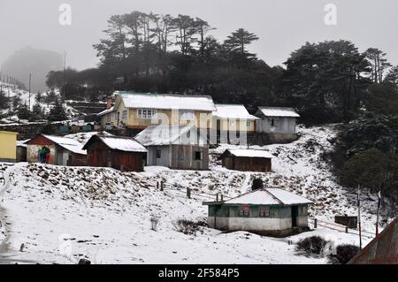 Gruppo di casa soggiorno cottage coperto di neve in remoto villaggio, Darjeeling Foto Stock