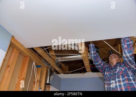 Sistema di tubi di ventilazione in cucina installazione interna di condotti per impianto di riscaldamento il soffitto montato in costruzione Foto Stock