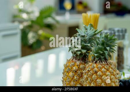 Due ananas su tavola bianca in cucina Foto Stock